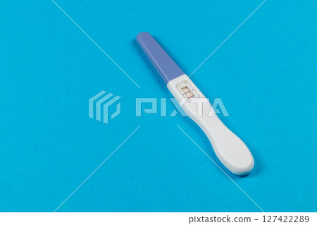 Pregnancy test on a blue background showing results clearly 127422289