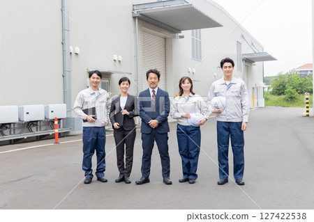 A group of company employees lined up in front of a building A group of company employees lined up in front of a building 127422538