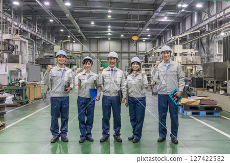 A group of workers pumping their fists in a factory A group of workers pumping their fists in a factory 127422582