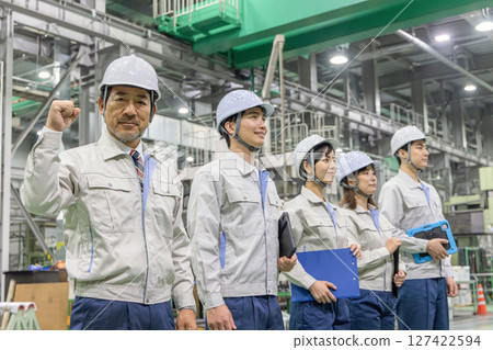 Workers pumping their fists in a factory Workers pumping their fists in a factory 127422594