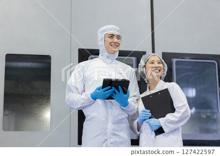 Worker in protective clothing using tablet PC in factory 127422597