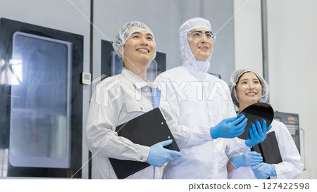 Worker in protective clothing using tablet PC in factory 127422598
