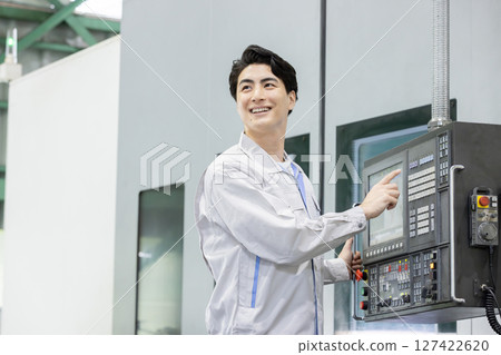 Male worker working in front of a factory control panel Male worker working in front of a factory control panel 127422620