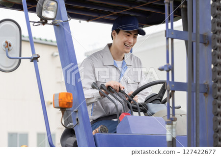 Male worker operating a forklift Male worker operating a forklift 127422677