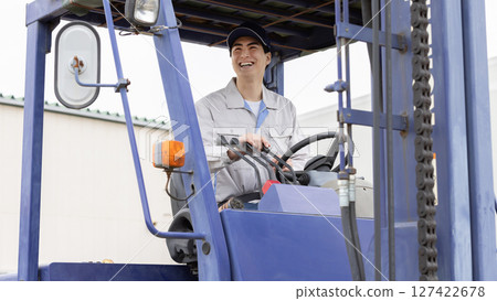 Male worker operating a forklift 127422678