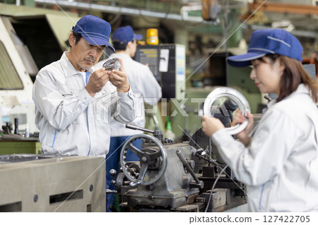 A group of workers inspecting products in a factory A group of workers inspecting products in a factory 127422705