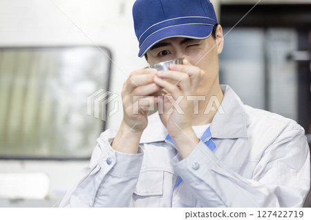 一名男工人在工廠檢查車床加工和銑削的產品 127422719