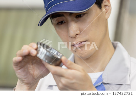 一名男工人在工廠檢查車床加工和銑削的產品 127422721