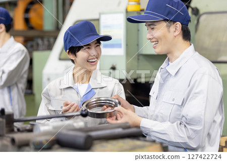 一名工人在工廠檢查車床和銑削產品 一名工人在工廠檢查車床和銑削產品 127422724