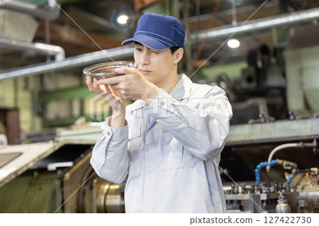 一名男工人在工廠檢查車床加工和銑削的產品 一名男工人在工廠檢查車床加工和銑削的產品 127422730