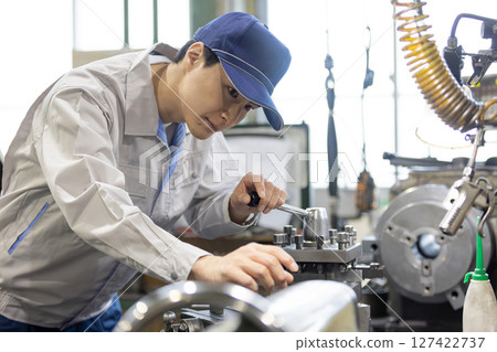 一名男工人在工廠操作機器 一名男工人在工廠操作機器 127422737