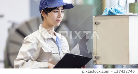 一名女工在控制面板上操作工廠機器 127422746