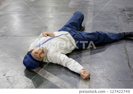 Worker collapses on factory floor Worker collapses on factory floor 127422749