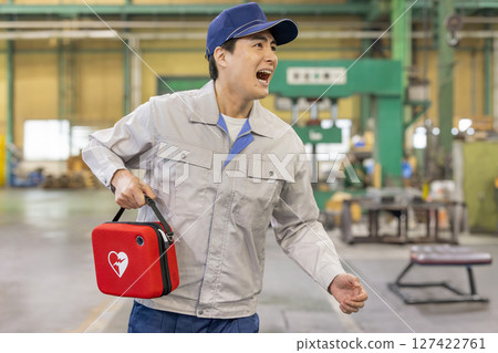 一名男工人帶著 AED 趕往工廠 127422761