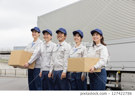 A group of delivery staff lined up in front of a truck 127422786