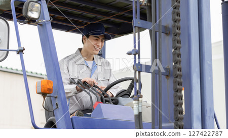 Male worker operating a forklift 127422787