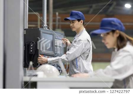 Male and female workers working in a factory Male and female workers working in a factory 127422797