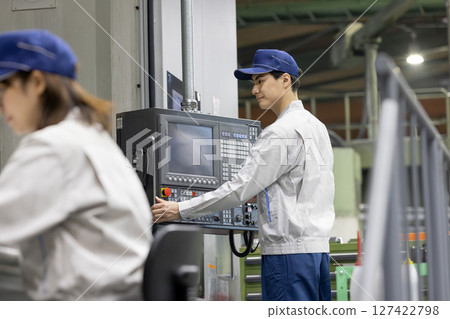 Male and female workers working in a factory Male and female workers working in a factory 127422798