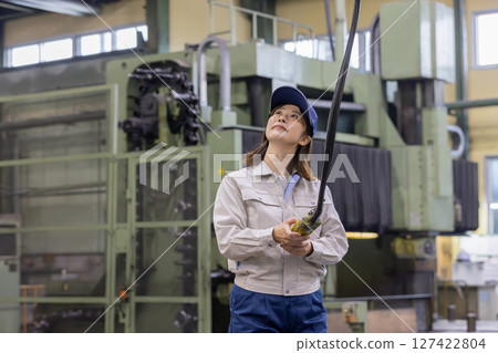 A worker operating the overhead crane/sling controller 127422804