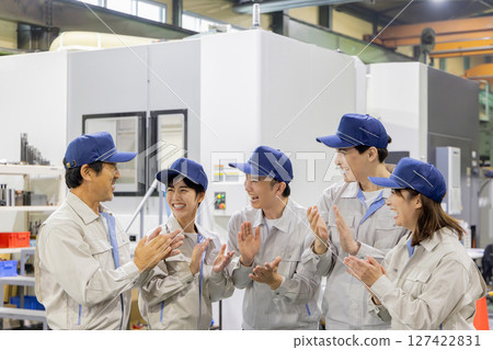 Group of workers clapping in a factory 127422831