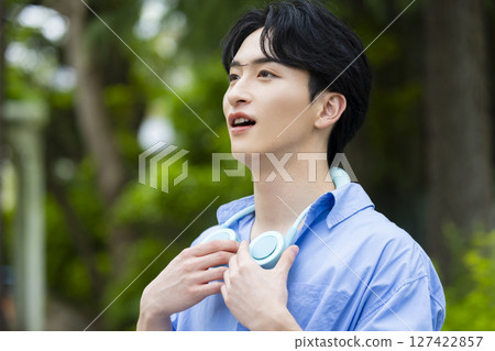 A young man wearing a neck cooler A young man wearing a neck cooler 127422857