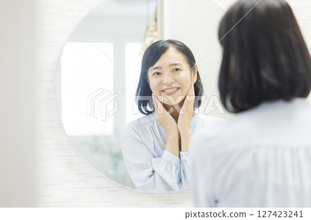 Senior woman watching a mirror Senior woman watching a mirror 127423241