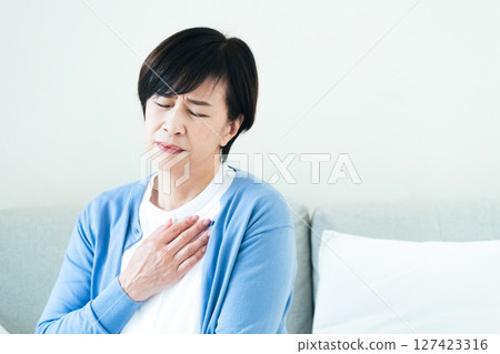 Middle-aged woman feeling chest pain Middle-aged woman feeling chest pain 127423316