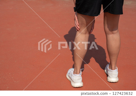 Cropped shot view of female runner suffering from hamstring strain. Occurs when one or more of the hamstring muscles at the back of the thigh are stretched too far and start to tear. 127423632