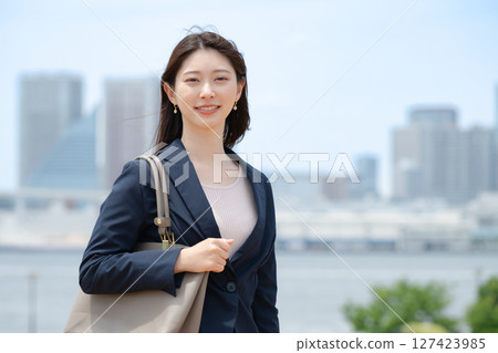 A woman standing against a blue sky 127423985