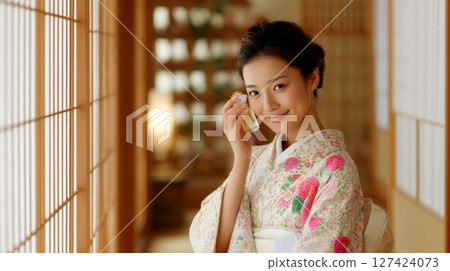 Asian young woman in floral kimono enjoying perfume in traditional setting. 127424073