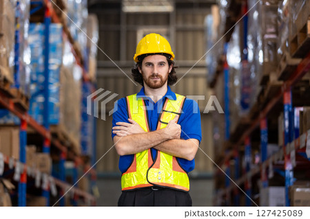 Portrait of man worker standing distribution center in warehouse with arm crossed looking at camera. Male person staff supply and delivery Logistics Company. Portrait of man worker standing distribution center in warehouse with arm crossed looking at camera. Male person staff supply and delivery Logistics Company. 127425089