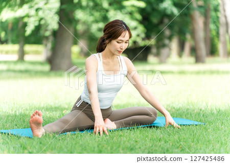 A female yoga instructor doing yoga, yoga class, pilates in the park or forest A female yoga instructor doing yoga, yoga class, pilates in the park or forest 127425486