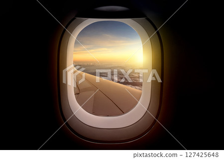 Airplane wing view from plane window over the landscape in sunlight. Summer background 127425648