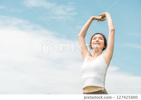穿著瑜珈服的女人在藍天下伸展(運動、深呼吸、日光浴、提神、緩解壓力) 穿著瑜珈服的女人在藍天下伸展(運動、深呼吸、日光浴、提神、緩解壓力) 127425800