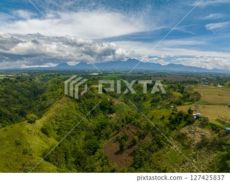 Green mountain valley and rainforest. Blue sky and clouds. Mindanao, Philippines. Green mountain valley and rainforest. Blue sky and clouds. Mindanao, Philippines. 127425837