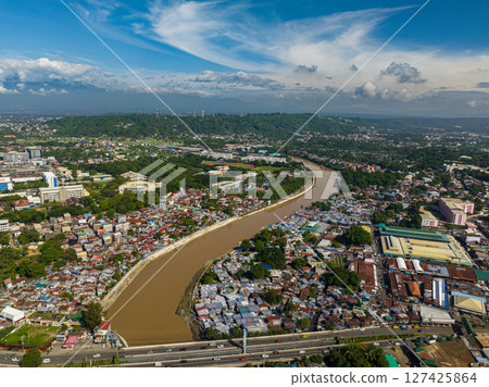 Downtown with buildings and houses in riverside. Blue sky and clouds. Davao City. Mindanao, Philippines. Downtown with buildings and houses in riverside. Blue sky and clouds. Davao City. Mindanao, Philippines. 127425864