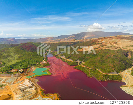 A dark red water in lake formation of nickel mine. Mining in an open pit. Mindanao, Philippines. A dark red water in lake formation of nickel mine. Mining in an open pit. Mindanao, Philippines. 127425898