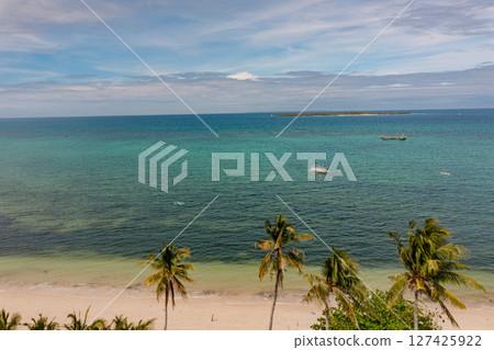 Top view of tropical island with palm trees. Ocean waves on sandy beach in Bantayan Island, Cebu, Philippines. Top view of tropical island with palm trees. Ocean waves on sandy beach in Bantayan Island, Cebu, Philippines. 127425922