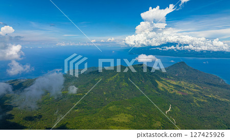 Top view of mountain with lush green forest in Camiguin Island. Blue sky and clouds. Philippines. 127425926