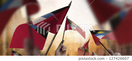 Antigua and Barbuda flags in their hands on a blurred urban background Antigua and Barbuda flags in their hands on a blurred urban background 127426607