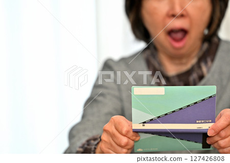 Seniors checking their savings passbook Seniors checking their savings passbook 127426808