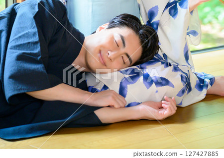 A man in a yukata closes his eyes and rests on his lap, a relaxing and soothing summer afternoon 127427885