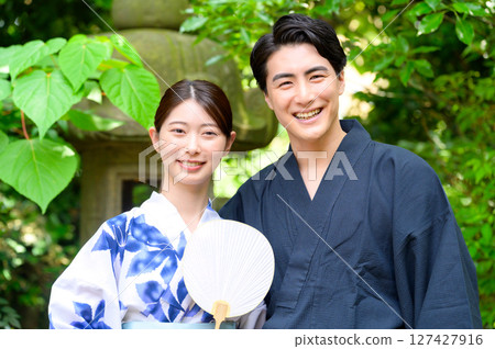 夏日肖像畫：在充滿自然氣息的花園中，身著浴衣的男子和女子依偎在一起，溫柔地微笑 127427916