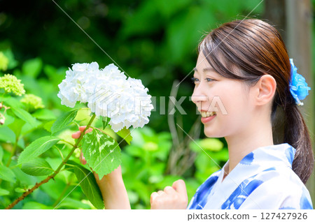 A summer nature portrait of a woman in a yukata smiling gently while gazing at white hydrangeas, feeling the season A summer nature portrait of a woman in a yukata smiling gently while gazing at white hydrangeas, feeling the season 127427926