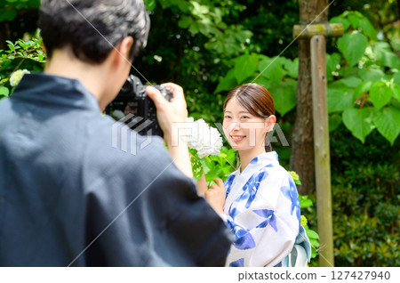 A behind-the-scenes shot of a man taking pictures of a woman in a yukata. A behind-the-scenes shot of a man taking pictures of a woman in a yukata. 127427940
