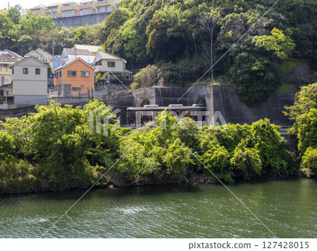 Train running along the river 127428015