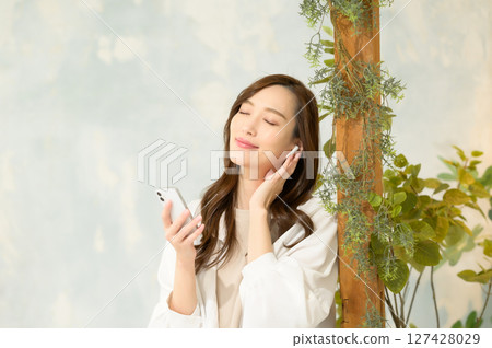 在智慧型手機上聽音樂的女人 在智慧型手機上聽音樂的女人 127428029