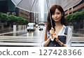 A woman holding an umbrella in the city 127428366