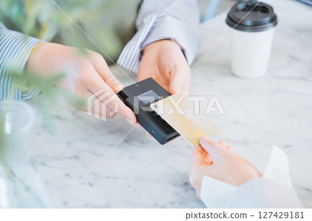 一位女士在商店購物時用信用卡進行觸摸付款 127429181