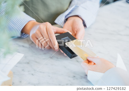 The hands of a woman buying products in a store by tapping her credit card for cashless payment 127429182